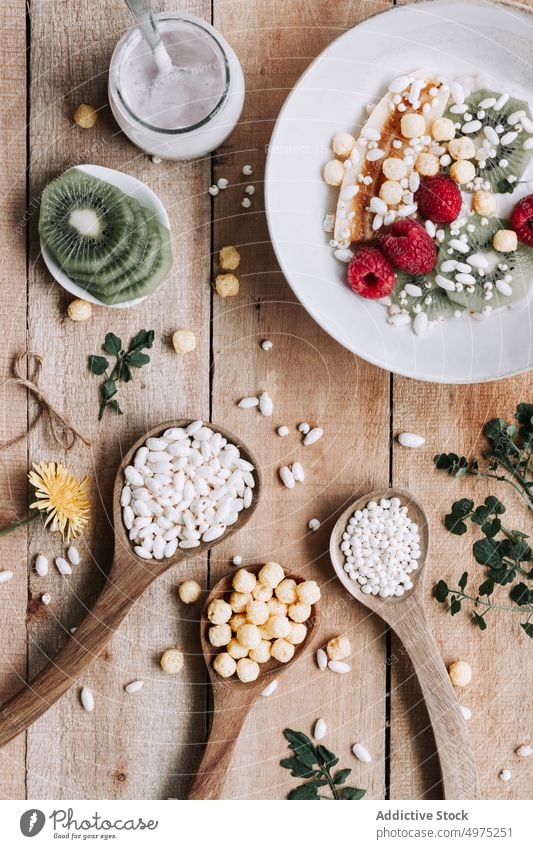 Schale mit frischen Früchten Holz hölzern rustikal Lebensmittel Tisch Gesundheit oben Hintergrund Banane Beeren Blaubeeren Schalen & Schüsseln Frühstück lecker