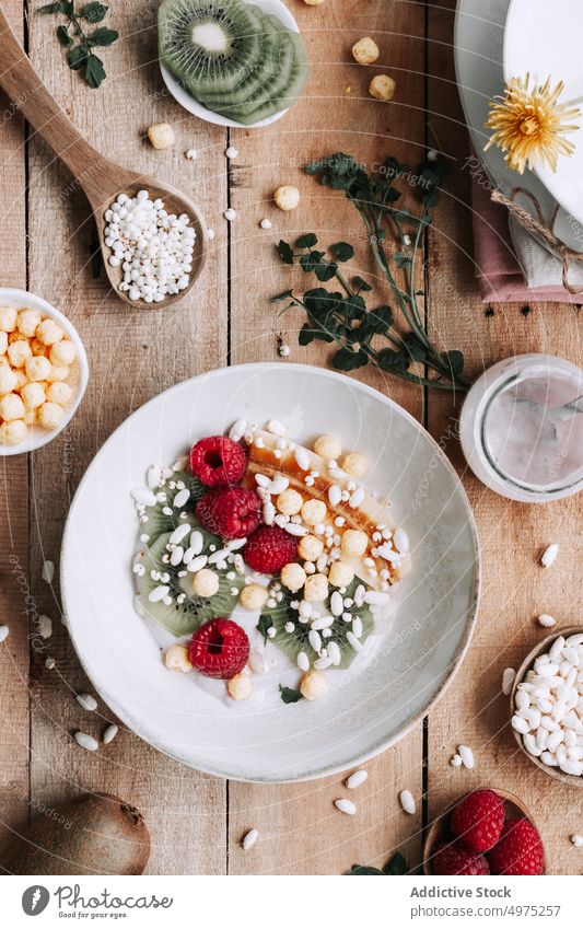 Schale mit frischen Früchten Holz hölzern rustikal Lebensmittel Tisch Gesundheit oben Hintergrund Banane Beeren Blaubeeren Schalen & Schüsseln Frühstück lecker