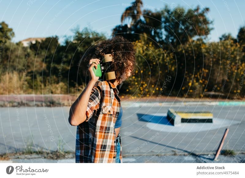 Anonyme ethnische Frau mit Penny Board Lochrasterplatte Straße Hipster Sommer Skater Afro-Look Sonnenuntergang heiter tausendjährig Afroamerikaner schwarz