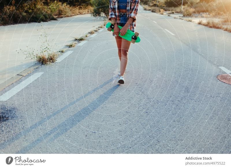 Ethnische Frau mit Penny Board Lochrasterplatte Straße Hipster Sommer Skater Afro-Look Sonnenuntergang Beine tausendjährig ethnisch Afroamerikaner schwarz