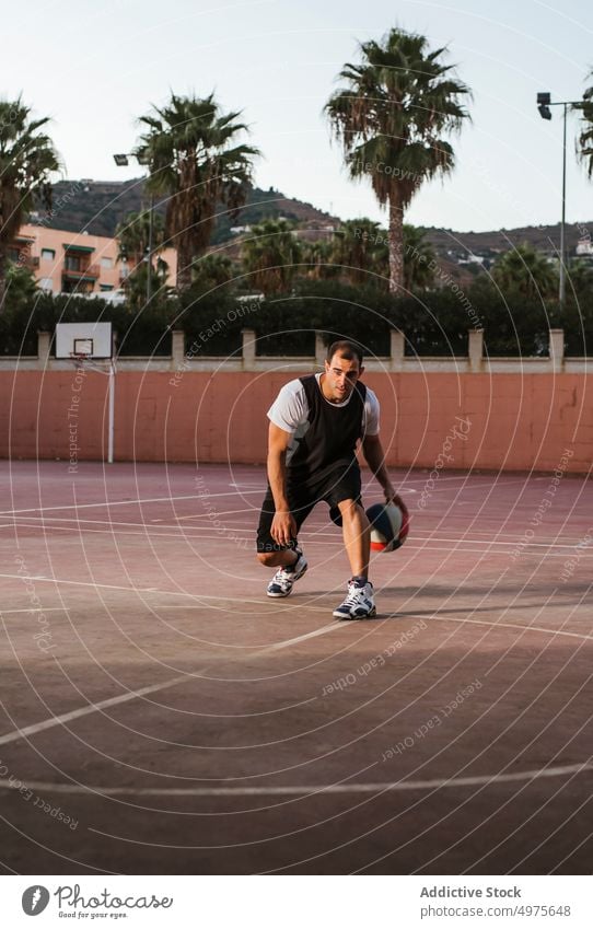 Nachdenklicher erwachsener Mann spielt Basketball auf dem Platz üben Training Dribbling spielen Sportpark Gericht Ball Sportler Feld Tatkraft Spieler Gesundheit