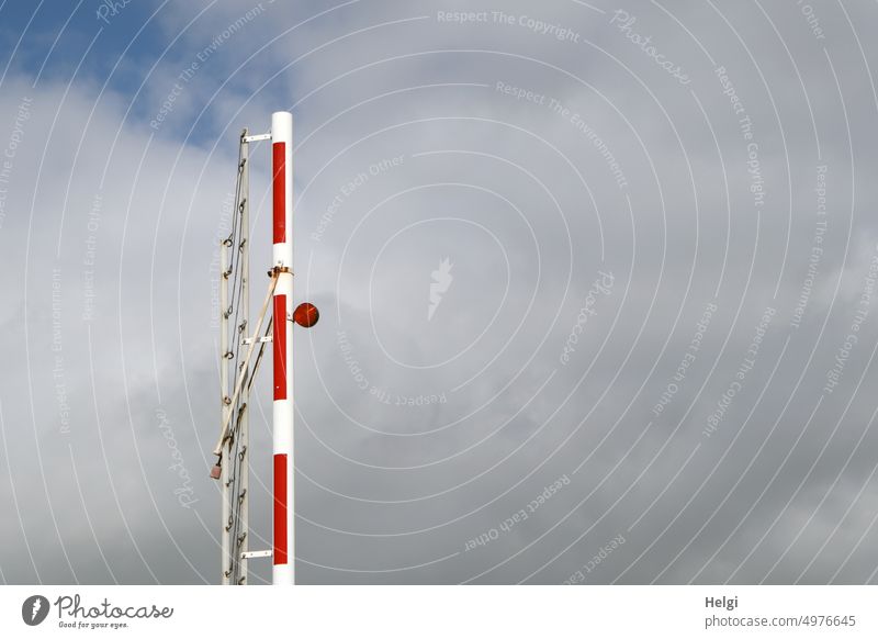 senkrecht stehende geöffnete Schranke mit roter Warnlampe vor bewölktem Himmel Sicherheit Barriere Verkehr Schutz Außenaufnahme Absperrung Verbote
