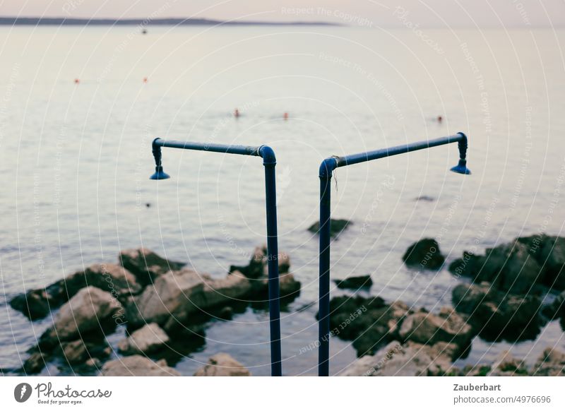 Zwei Duschen am felsigen Ufer des Mittelmeers vor Losinj am Abend Meer baden Strand Felsen Kroatien Urlaub schwimmen Badende Schwimmer abduschen Rohre Brause