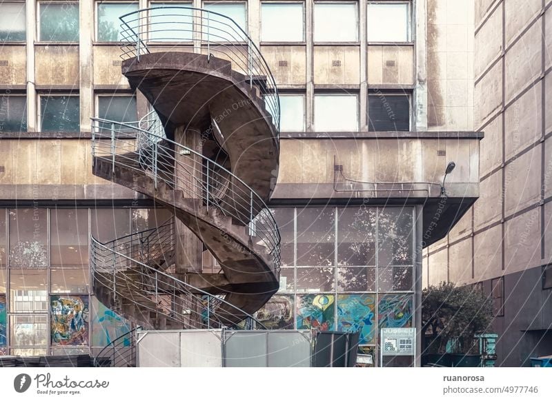 Spindeltreppe neben einem alten zweistöckigen Gebäude, schmutzig und gestrichen Wendeltreppe dreckig Fenster gemalt altersschwach abgenutzt verfallen Freitreppe