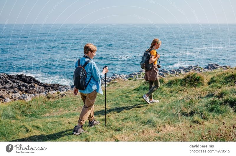 Großmutter und erwachsene Enkelin wandern an der Küste entlang Frauen Trekking Ufer MEER Familie Erwachsener Landschaft Senior Zusammensein Rucksack Spaziergang