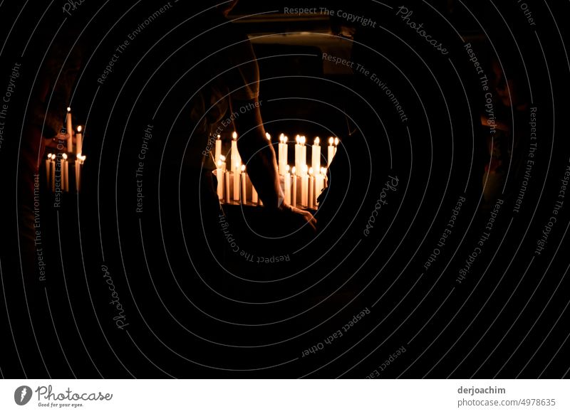 Eine Kerze anzünden in der Kirche. Kerzenlicht leuchten Flamme Wärme Kerzenschein Kerzenflamme Licht brennen Hoffnung Meditation gemütlich dunkel Wachs