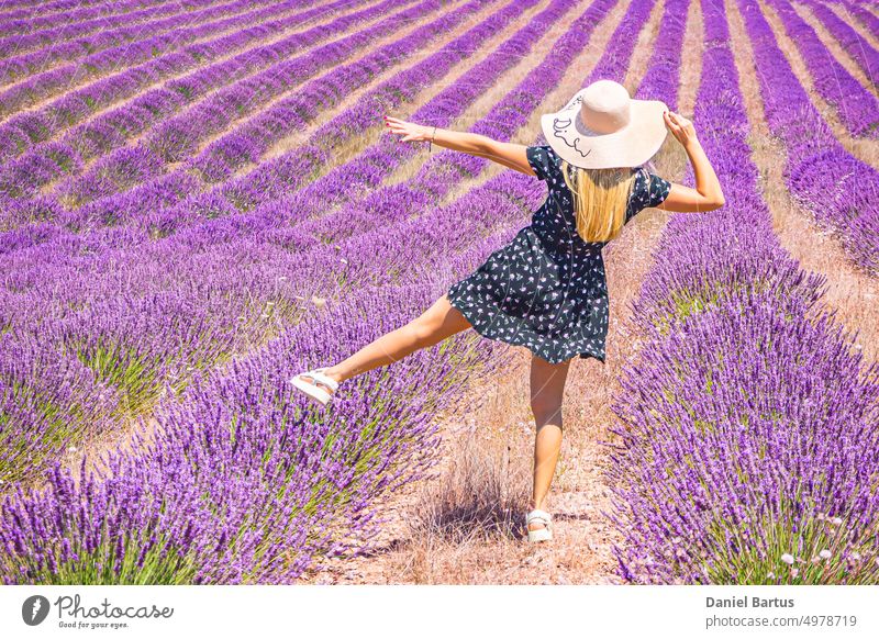 Nahaufnahme eines jungen Mädchens in einem geblümten Kleid mit einem Hut auf dem Kopf zwischen Lavendel in der südlichen Provence Valensole Frankreich schön