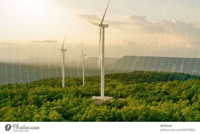 Windenergie. Windkraft. Nachhaltige, erneuerbare Energie. Windturbinen erzeugen Strom. Windmühlenpark auf einem Berg mit Sonnenuntergang am Himmel. Grüne Technologie. Erneuerbare Ressource. Nachhaltige Entwicklung.