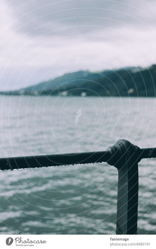 Regentropfen am Geländer vor dem Panorama des Bodensees Bregenz Wasser Tropfen hängen Unschärfe blau grün grau grau in grau Österreich Detailaufnahme regnerisch