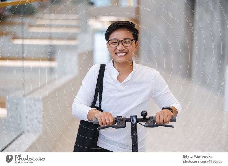 Junger Mann mit einem Elektroroller echte Menschen natürlich junger Erwachsener Großstadt urban Schüler positiv Lächeln heiter Karriere selbstbewusst gelungen