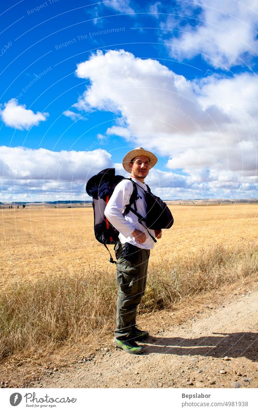 Pilger mit Rucksack schaut in die Kamera, Jakobsweg - Spanien Ackerbau Ballen Camino Anspruch Wolken wolkig compostela Mais Kornfeld Land Landschaft Ernte de