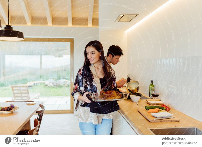 Seitenansicht eines attraktiven Paares beim Kochen Vorbereitung Küche Gemüse hispanisch Schürze Schneiden Schneidebrett Tisch Frau Mann jung Abendessen