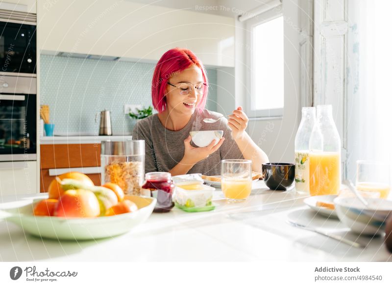 Junge Frau beim gesunden Frühstück zu Hause Gesundheit Morgen heimwärts Lächeln Tisch gemütlich essen Küche Appartement modern jung rosa Haare gefärbtes Haar