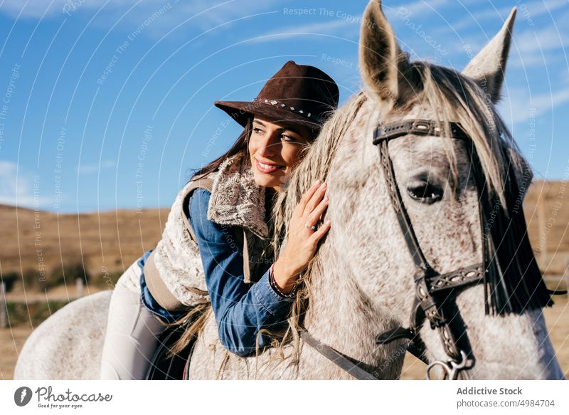 Frau sitzt auf weißem Pferd in der Natur Reiter ländlich hell Sonnenlicht pferdeähnlich Sitzen Pferderücken Sattel Erholung Lifestyle züchten Bauernhof