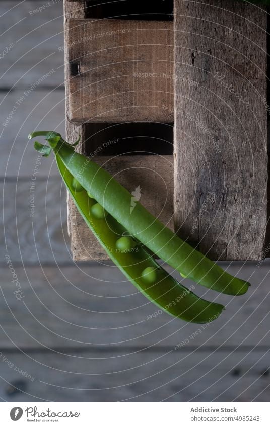 Nahaufnahme einer Erbsenschote auf Holz Hülse grün frisch Vitamin Lebensmittel Gemüse organisch offen Pflanze Hülsenfrüchtler Ernährung Reihe Samen roh Ernte