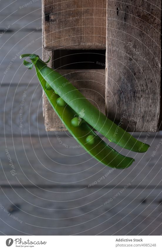 Nahaufnahme einer Erbsenschote auf Holz Hülse grün frisch Vitamin Lebensmittel Gemüse organisch offen Pflanze Hülsenfrüchtler Ernährung Reihe Samen roh Ernte