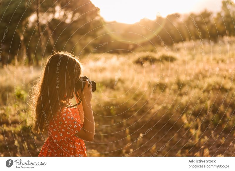 Kleines Mädchen fotografiert eine Landschaft an einem sonnigen Tag fotografierend Sommer Feld Natur Fotokamera Fotografie Glück Wiese schön bezaubernd rot Kind