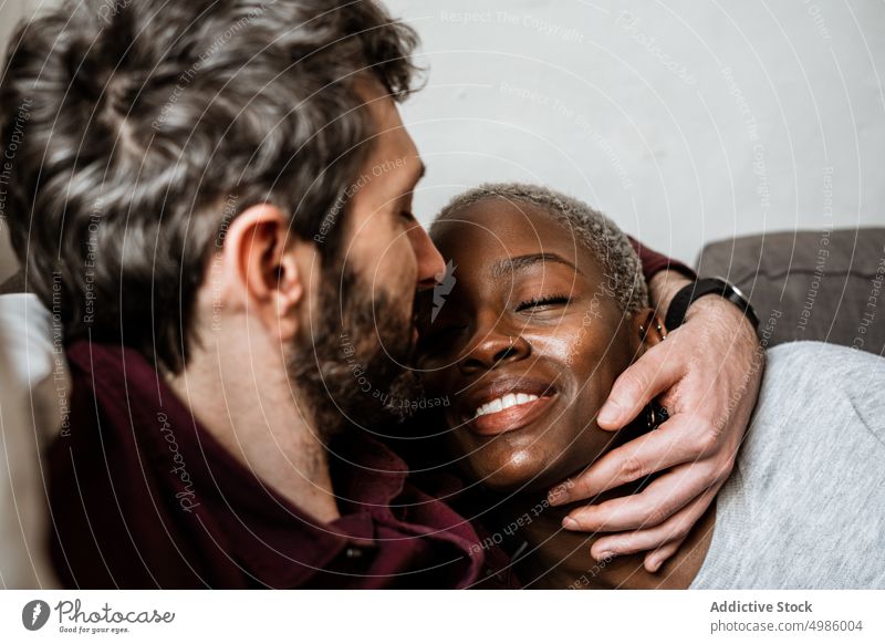 Junges multiethnisches Paar ruht sich auf dem Sofa aus kuscheln Liege schlafend Harmonie Windstille heimwärts Liebe sich[Akk] entspannen Wohnzimmer Bonden