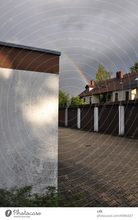 In die Jahre gekommener Garagenhof mit Reihenhäusern und Regenbogen geplastert Einfahrt Häuser Häuserzeile Mauer Stadt städtisches Leben Bebauung Gebäude Wand