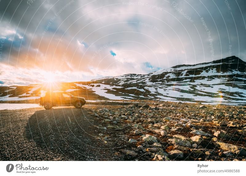 Aurlandsfjellet, Norwegen. Auto SUV geparkt in der Nähe Aurlandsfjellet Scenic Route Straße im Sommer norwegischen Landschaft. Beliebtes Reiseziel in Sonnenuntergang Lichter. Sonnenschein