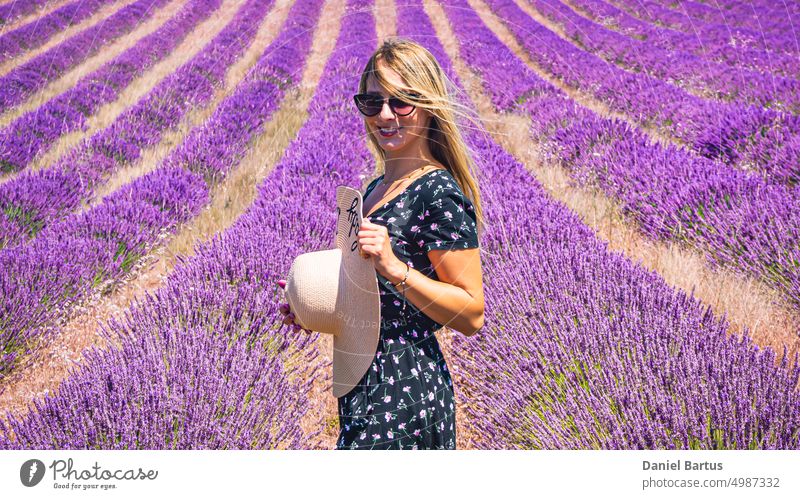 Nahaufnahme eines jungen Mädchens in einem geblümten Kleid mit einem Hut auf dem Kopf zwischen Lavendel in der südlichen Provence Valensole Frankreich schön