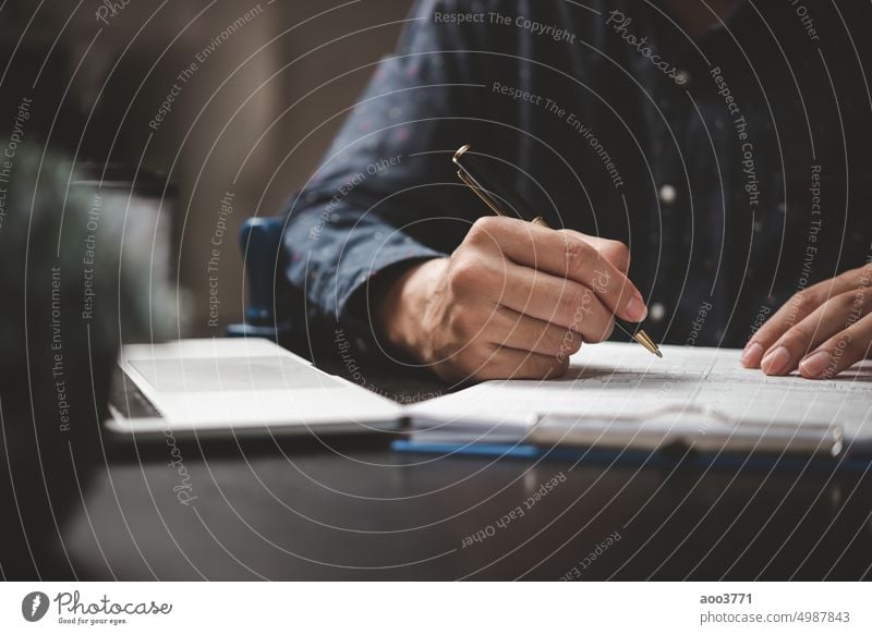 Hand hält Stift schreiben Papierkram Business-Dokument finanzielle Investition oder Unterschrift Vertrag Job und Versicherung auf dem Schreibtisch. Schriftstück