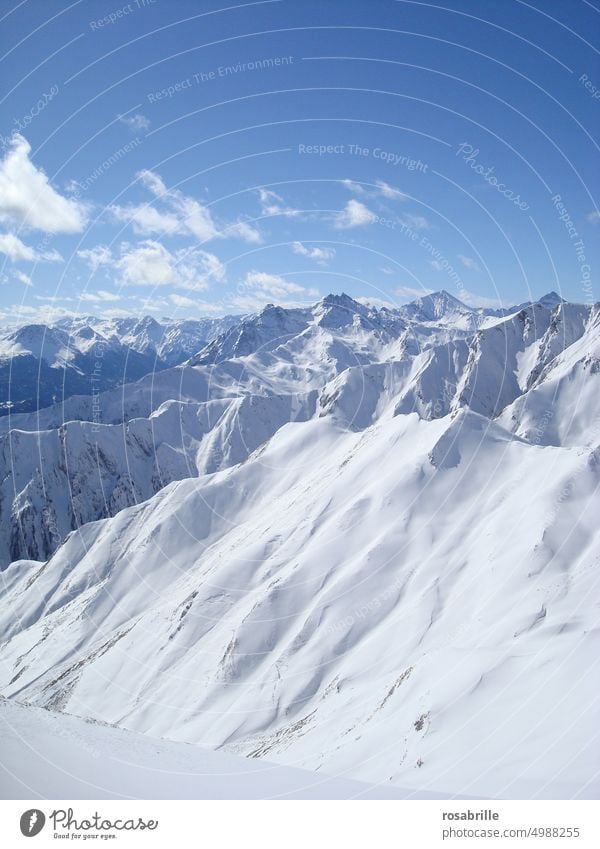 sonnige Winterlandschaft mit hohen Bergen Schnee kalt eingeschneit wolkig frieren eiskalt Kälte Winterzeit winterlich verschneit Landschaft Hügel hügelig Natur