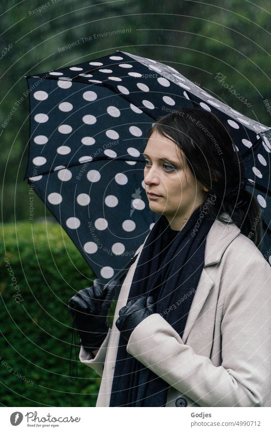 [HH Unnamed Road Tour] trauernde Frau mit Regenschirm auf dem Friedhof Trauer Traurigkeit Tod Grabstein Außenaufnahme Punkte Vergänglichkeit Religion & Glaube