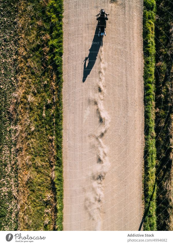 Unbekannter Motorradfahrer fährt auf einer Landstraße Mitfahrgelegenheit Fahrrad Straße Landschaft Person Laufwerk ländlich Fahrzeug Verkehr reisen Abenteuer