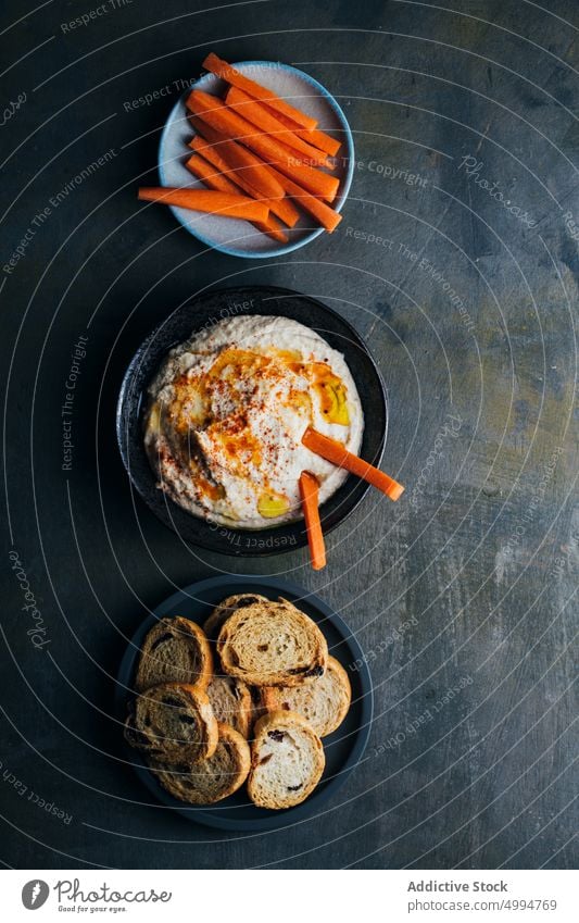 Hausgemachter Hummus, fertig zum Servieren Amuse-Gueule Schalen & Schüsseln Brot Möhre Kichererbsen cremig Dip Lebensmittel Gesundheit selbstgemacht Mittagessen