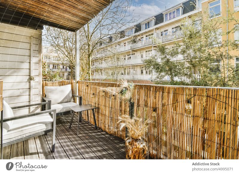 Hinterhof eines Hauses mit einem modernen Sitz Pflanze Tisch Baum Gras Stuhl grün im Freien Außenseite heimwärts Architektur Fenster Garten hölzern