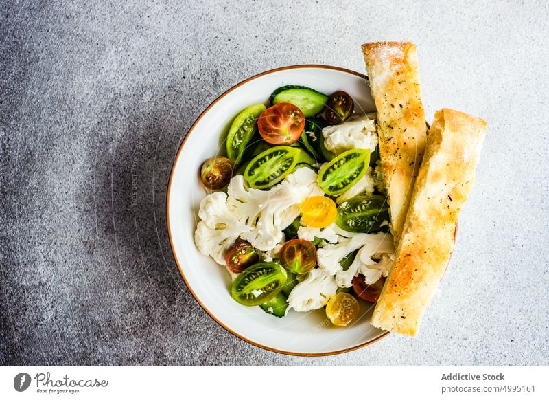 Gesunder Gemüsesalat in der Schüssel Schalen & Schüsseln Blumenkohl Kirschtomate konkreter Hintergrund Salatgurke Besteck Diät Focaccia frisch Gesundheit Keton