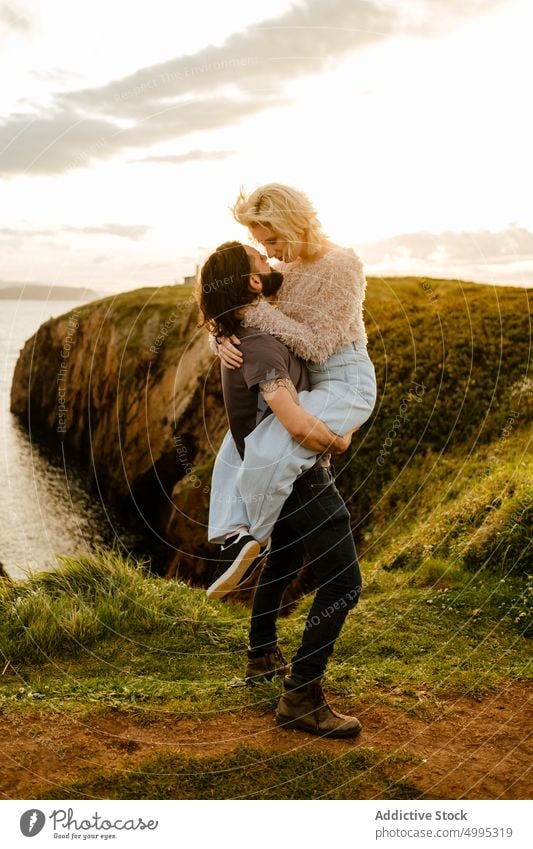 Mann hebt Frau auf Klippe am Meer Paar Umarmung Liebe Sonnenuntergang heben Termin & Datum romantisch wolkig Himmel Aviles Asturien Spanien MEER Abend Natur