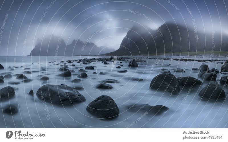 Strand und Felsen gegen bedeckten Himmel strömen felsig Natur Landschaft Meer reisen MEER Stein Klippe Cloud Norwegen Vik Strand Tourismus Reise rau Wasser