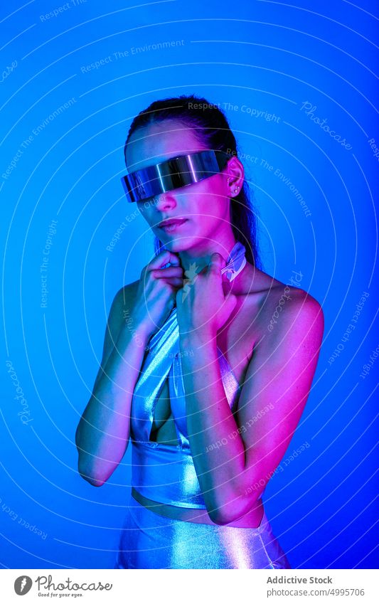 Selbstsichere futuristische Frau erkundet den Cyberspace in einer VR-Brille Virtuelle Realität Erfahrung Stil selbstbewusst zuschauen digital neonfarbig