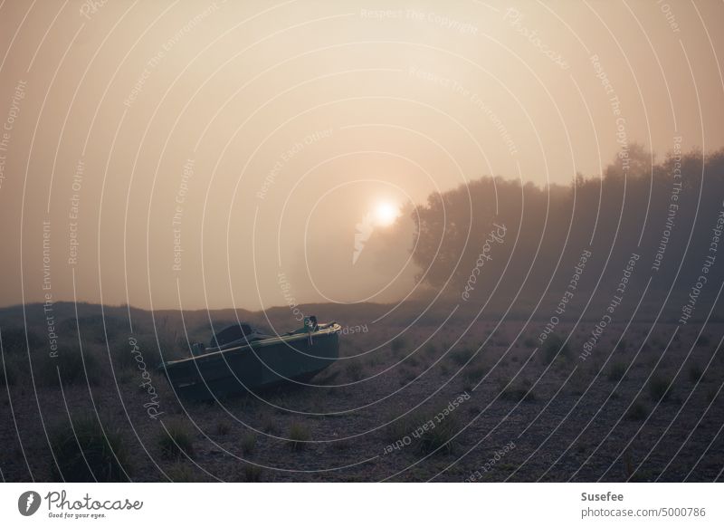 Ein Boot auf dem Trockenen im Nebel mit Morgensonne Landschaft Sonne Sonnenaufgang Himmel Gegenlicht Sonnenstrahlen Morgendämmerung Menschenleer Schönes Wetter