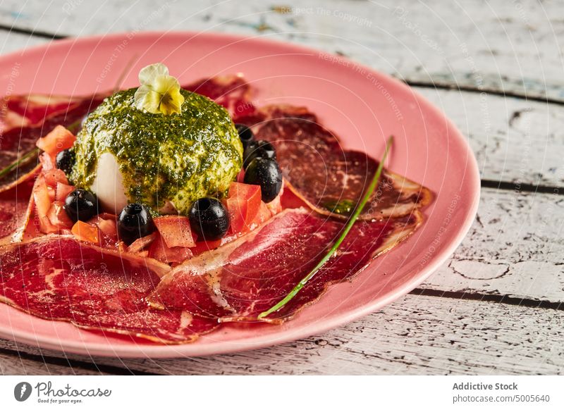 Leckerer Tomatensalat auf dem Teller Salatbeilage Burrata Prosciutto Pesto Saucen oliv Käse Speise italienische Küche Feinschmecker lecker Lebensmittel