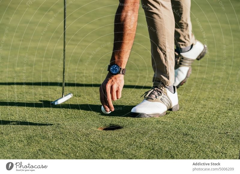 Sportler mit Putter und Golfball im Feld Athlet Ball vorbereiten professionell nach vorne lehnen Mann Natur Golfer Kurs Spieler aristokratisch Schläger und Ball