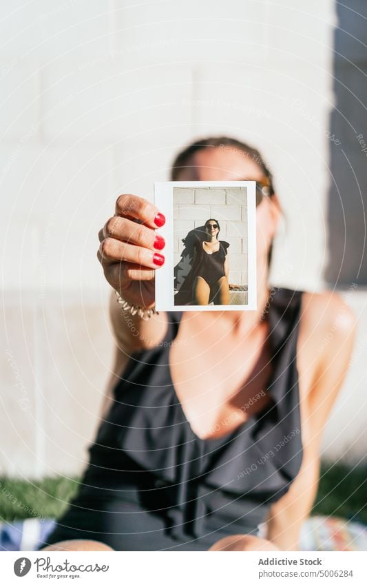 Frau zeigt Sofortfoto am Pool Foto Beckenrand Sommer zeigen sofort Porträt Gedächtnis Selbst Badeanzug Sommerzeit jung Urlaub ruhen sich[Akk] entspannen Stil