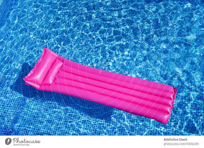 Aufblasbare Matratze im Freibad Beckenrand Pool aufblasbar Sommer Schlafmatratze Wasser rosa farbenfroh Sonnenlicht Schwimmer durchsichtig übersichtlich blau