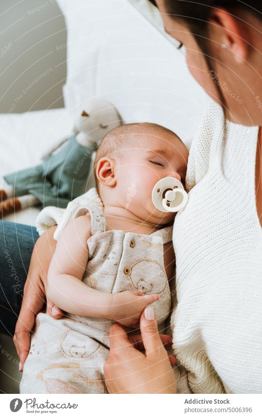 Anonyme Mutter, die ihr ruhiges Baby füttert, während sie sich zu Hause auf dem Bett entspannt Futter Säugling Kind Eltern essen heimwärts Mama Komfort Pflege