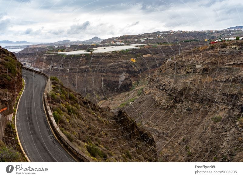 Klassische Landschaft auf Gran Canaria mit einer Straße und einer Bananenplantage Kanarische Inseln vulkanisch Schonung Wildnis Felsen Stein Sommer Schlucht