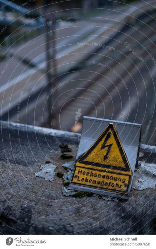 Warnschild über Bahngleisen Hochspannung Hochspannungsleitung Hochspannungsmast Hochspannungsleitungen Energie Warnung Lebensgefahr lebensgefährlich