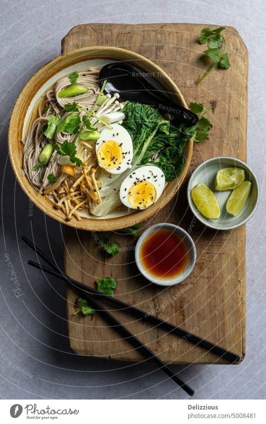 Ansicht von oben auf japanische Ramen-Suppe mit gekochtem Ei auf Holzbrett, Kopierraum Nudel Japanisch Speise Lebensmittel Schalen & Schüsseln Rezept Nudeln