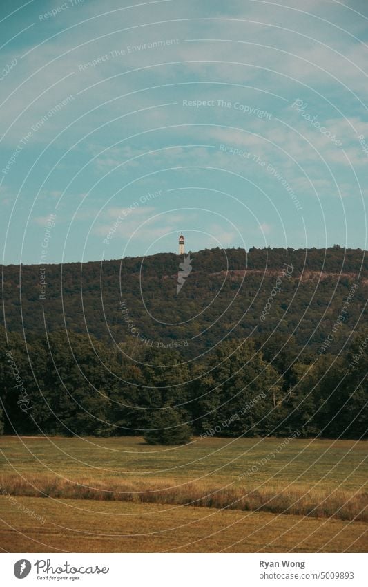 Turm auf einem Berggipfel an einem bewölkten Sommertag. Landschaft Himmel Berge u. Gebirge Natur Ansicht Panorama panoramisch Baum Feld Fluss Wolken Hügel grün