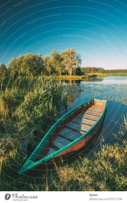 Alte hölzerne Rudern Fischerboot in der Nähe von See oder Fluss Küste am schönen Sommer sonnigen Tag. Typische Natur von Belarus oder westeuropäischen Teil Russland