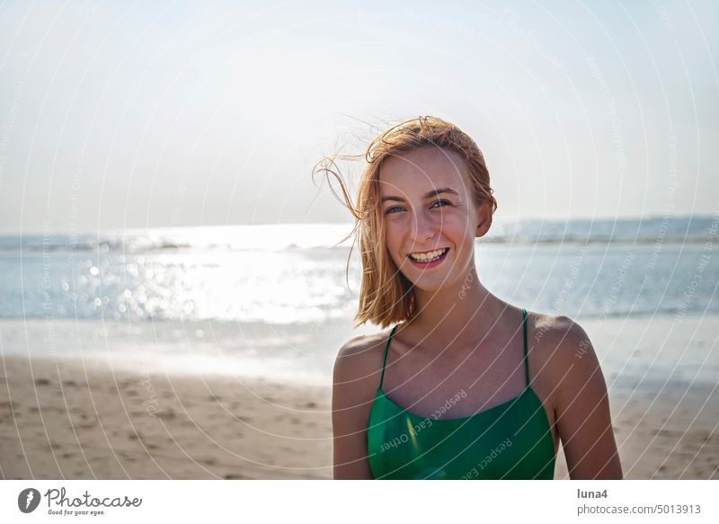 fröhliches Mädchen in grünem Kleid am Strand Meer lachen Glück teenager glücklich Freude unbeschwert Lebensfreude jung Jugend rote Haare lächeln Jugendliche