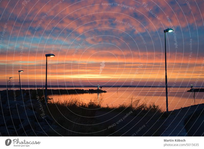 Sonnenuntergang in Schweden am Hafen des Vaetternsees. Leuchtturm im Hintergrund in der Abenddämmerung. Landschaftsaufnahme in Skandi hafen Visingsoe See