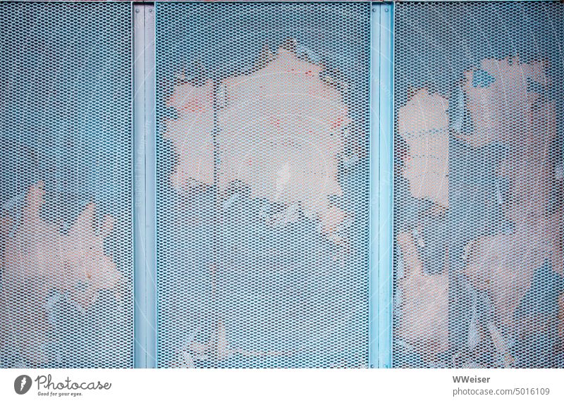 Urbaner Verfall: Wolkenförmige Löcher in einer blauen Wand hinter Gitter abgenutzt Abnutzung urban Stadt öffentlich Raum Station abgeplatzt verkleidung Schutz