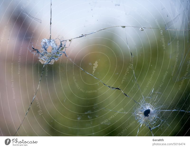 Einschussloch in gesprungenem Fensterglas abstrakt Unfall Hintergrund gebrochen zerbrochenes Glas kaputtes Fenster Gewehrkugel Einschusstreffer Einschussstelle